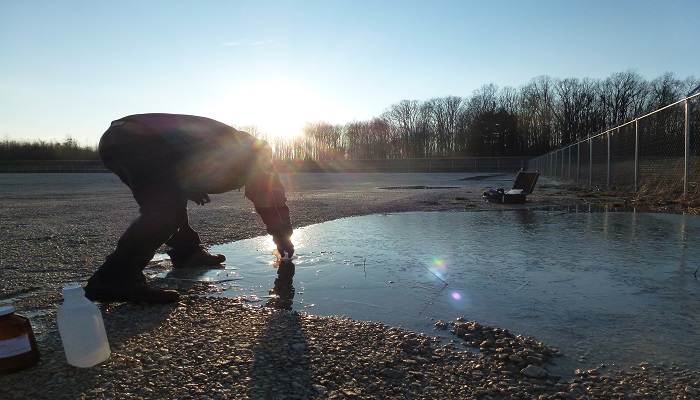 a man testing water quality at a pond